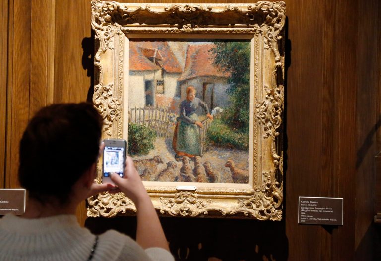 FILE - In this Feb. 8, 2014, file photo, a visitor to the Fred Jones Jr. Museum of Art at the University of Oklahoma in Norman, Okla., takes a photograph of a piece called 