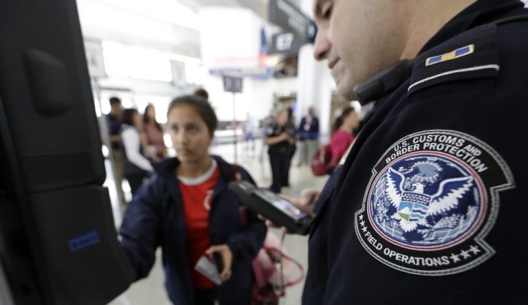 Customs and Border Protection officer Julio Corro, right, helps a passenger navigate one of the new facial recognition kiosks at a United Airlines gate before boarding a flight to Tokyo, Wednesday, July 12, 2017, at George Bush Intercontinental Airport, in Houston.