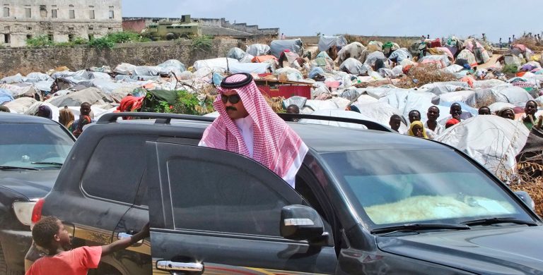 FILE - In this Aug. 27, 2011 file photo, an unidentified aide to Saudi Prince Al Waleed bin Talal Bin Abdulaziz Alsaud, shakes hands with a child during a visit to a refugee camp in Mogadishu, Somalia.