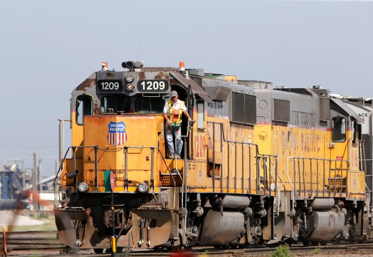 A Union Pacific employee uses a remote control device to drive a locomotive in a rail yard in Council Bluffs, Iowa.