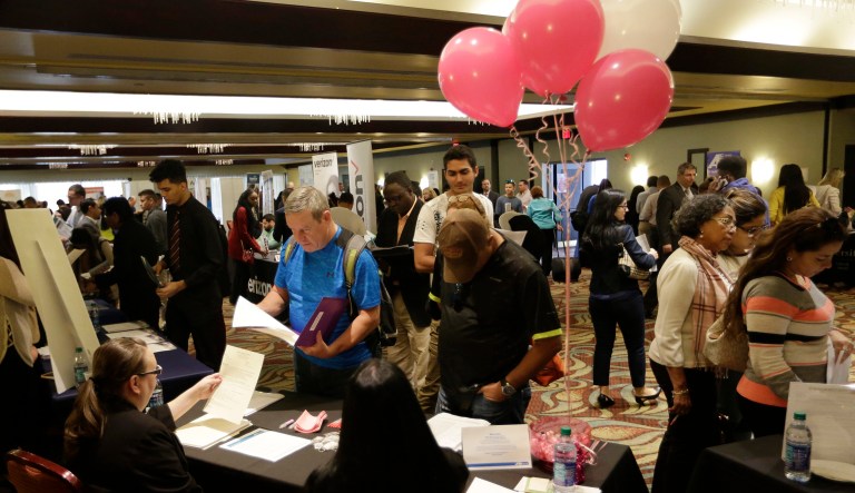 Job applicants talk with employees of Hialeah Park, at a JobNewsUSA job fair in Miami Lakes, Fla.