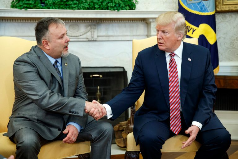 Former President Donald Trump shakes hands with Don Bouvet in the Oval Office of the White House, Friday, Feb. 9, 2018, in Washington. Trump gifted $10,000 to Bouvet's son Shane, a campaign volunteer, and that money was used to pay for Don Bouvet's cancer treatment.