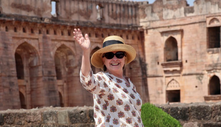 Former U.S. Secretary of State Hillary Clinton waves to media during her visit to India.