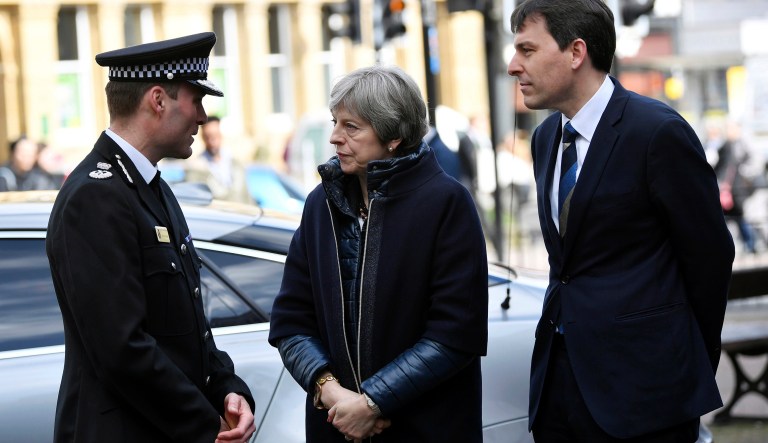 Britain's Prime Minister Theresa May is briefed by members of the police as she views the area where former Russian double agent Sergei Skripal and his daughter were found critically ill, in Salisbury, England.