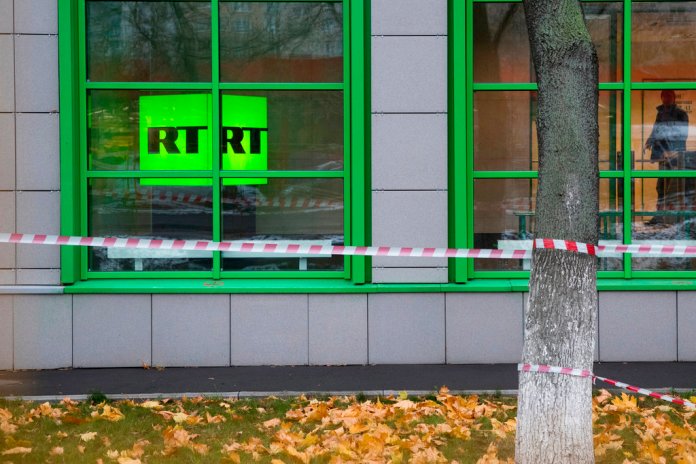 FILE - In this Oct. 27, 2017, file photo, Russian state-owned television station RT logo is seen at the window of the company's office in Moscow, Russia. Russian-backed TV channel RT disappeared from broadcasts around Washington.