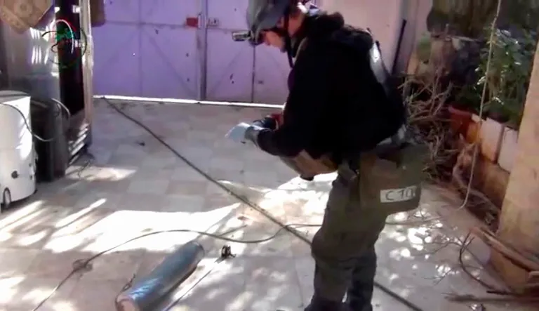 A UN staff member measuring and photographing a canister in Damascus, Syria. Chemical weapons have killed hundreds of people since the start of Syria's conflict. 