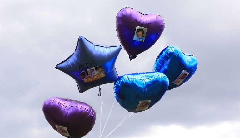 A woman holds balloons with photos of Alfie Evans, outside Alder Hey Children's Hospital, following the death of the 23-month old who was being treated at the hospital, in Liverpool, England. The sick British toddler whose parents won support from Pope Francis during a protracted legal battle over his medical treatment, died early Saturday.