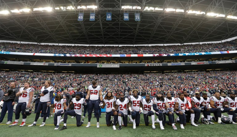 Players kneel and stand during the singing of the national anthem before an NFL football game. NFL owners have approved a new policy aimed at addressing the firestorm over national anthem protests, permitting players to stay in the locker room during the "The Star-Spangled Banner" but requiring them to stand if they come to the field.