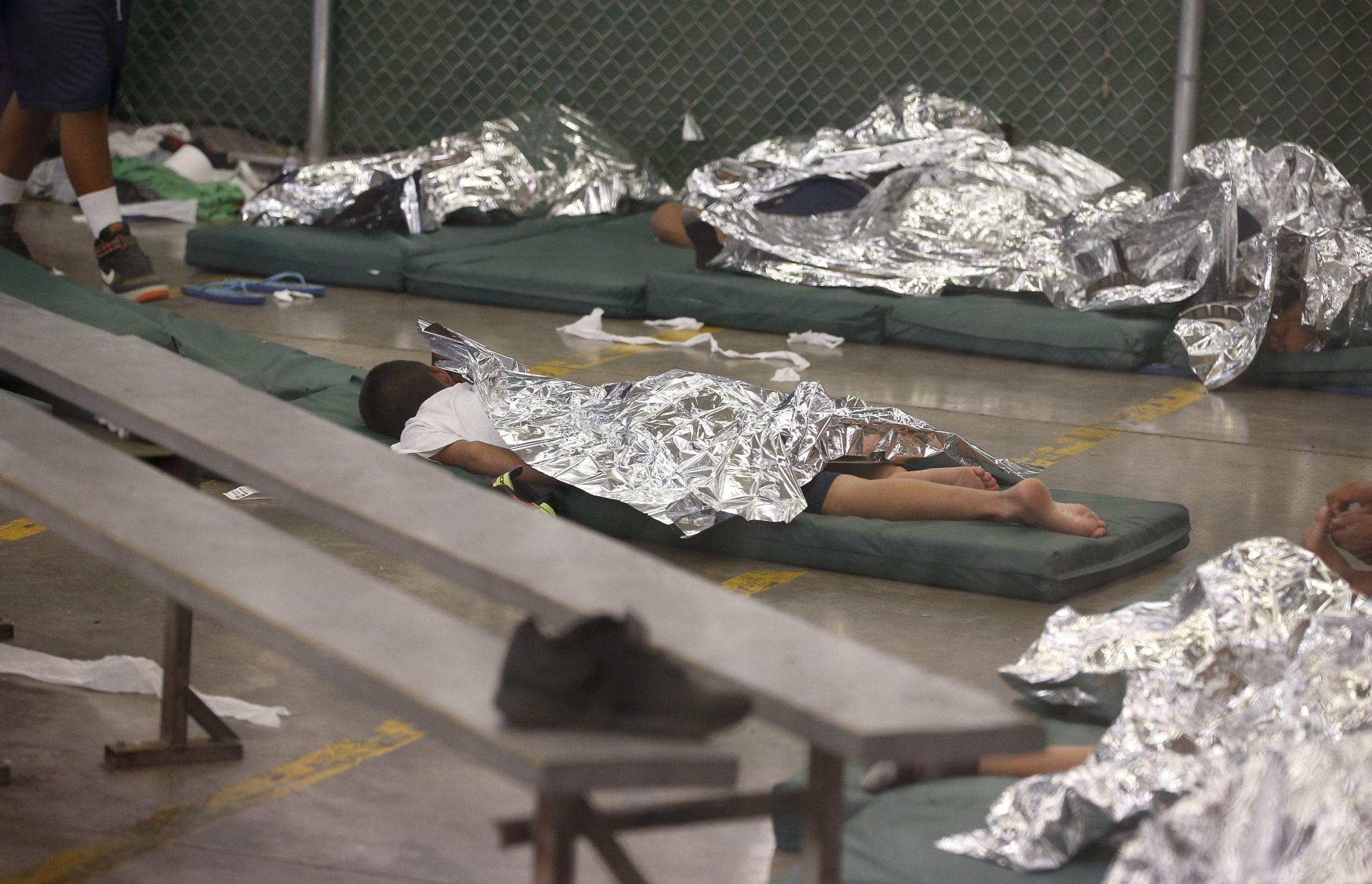 In this June 18, 2014, file photo, young boys sleep in a holding cell where hundreds of mostly Central American immigrant children are being processed and held at the U.S. Customs and Border Protection Nogales Placement Center in Nogales, Arizona.