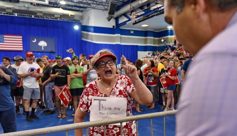Maria Rojas, from West Columbia berates CNN's Jim Acosta, right, before President Trump speaks to the crowd in West Columbia, S.C. 