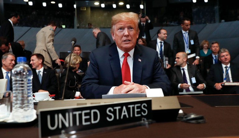 President Trump takes his seat as he attends the multilateral meeting of the North Atlantic Council in Brussels. 