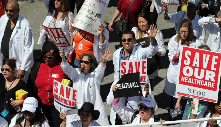 Healthcare professionals join hundreds of people marching through downtown Los Angeles protesting President Trump's plan to dismantle the Affordable Care Act. 