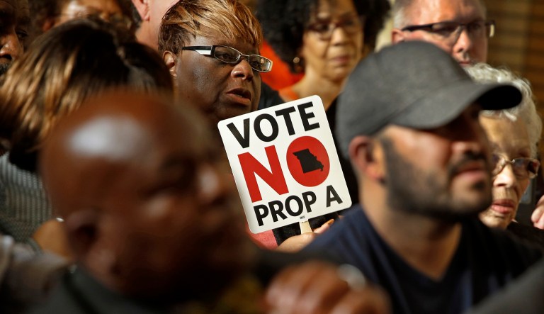 People opposing Proposition A listen to a speaker during a rally in Kansas City, Mo. Missouri votes Tuesday on a right-to-work law, a voter referendum seeking to ban compulsory union fees in all private-sector workplaces.