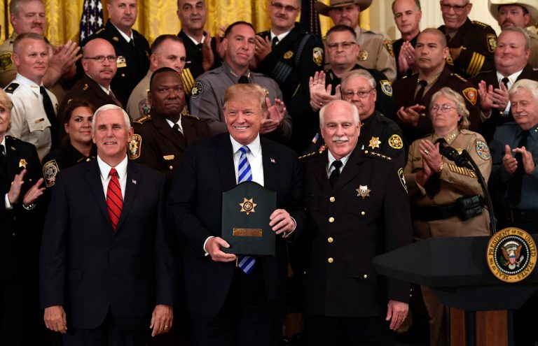 President Donald Trump, center, poses for a photos with Vice President Mike Pence, front left, and Bristol County, Mass., Sheriff Thomas Hodgson, front right, during an event with sheriffs in the East Room of the White House in Washington, Wednesday, Sept. 5, 2018.