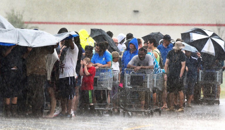 The rain continued in southeastern North Carolina, Sunday, in Rocky Point, N.C. as customers waiting in line at the local grocery store get pelted during a deluge from Tropical Storm Florence. 