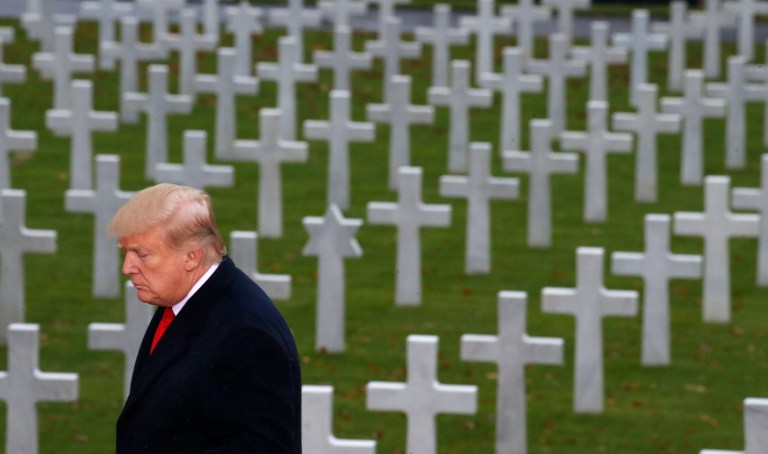 President Donald Trump is backdropped by headstones as he prepares to speak during an American Commemoration Ceremony, Sunday Nov. 11, 2018, at Suresnes American Cemetery near Paris.