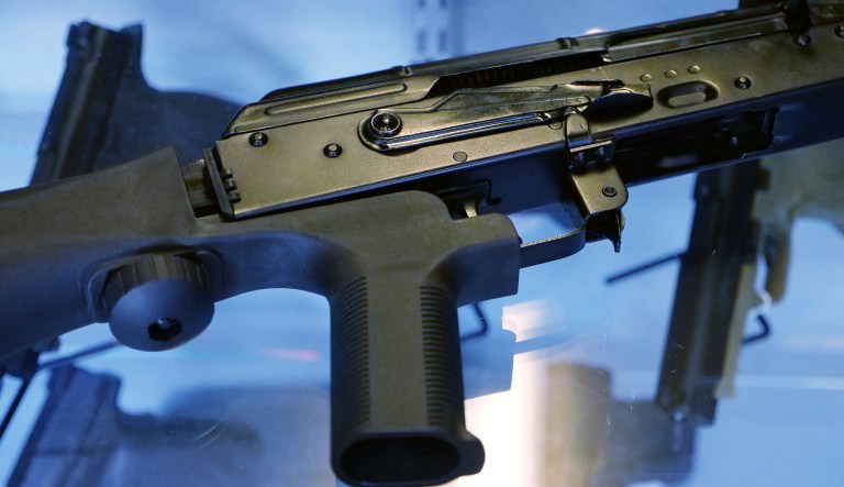 In this Oct. 4, 2017 file photo, a little-known device called a "bump stock" is attached to a semi-automatic rifle at the Gun Vault store and shooting range in South Jordan, Utah. The Trump administration is moving to officially ban bump stocks, which allow semi-automatic weapons to fire rapidly like automatic firearms.  A senior Justice Department official said Tuesday bump stocks will be banned under the federal law that prohibits machine guns. It will take effect in late March.