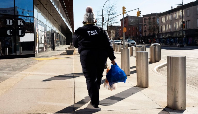 TSA worker Amelia Williams walks with bags of groceries after visiting a food bank for government workers affected by the shutdown, Tuesday, Jan. 22, 2019, in the Brooklyn borough of New York.