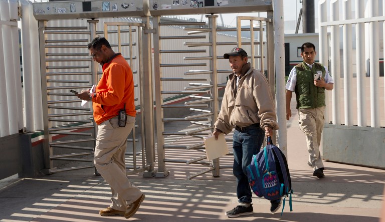 Carlos Catarldo Gomez, of Honduras, center, is escorted by Mexican officials after leaving the United States, the first person returned to Mexico to wait for his asylum trial date, in Tijuana, Mexico, Tuesday, Jan. 29, 2019. 