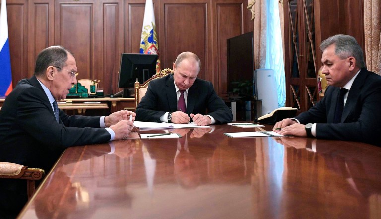 Russian President Vladimir Putin, center, attends a meeting with Russian Foreign Minister Sergey Lavrov, left, and Defense Minister Sergei Shoigu in the Kremlin in Moscow, Russia.