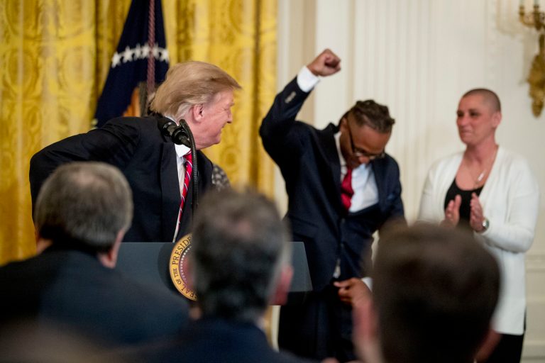 Gregory Allen, a First Step Act beneficiary, second from right, gestures after being invited to the podium to speak by President Donald Trump, left, during the 2019 Prison Reform Summit and First Step Act Celebration in the East Room of the White House in Washington, Monday, April 1, 2019. Also pictured is another First Step Act beneficiary April Johnson, right.