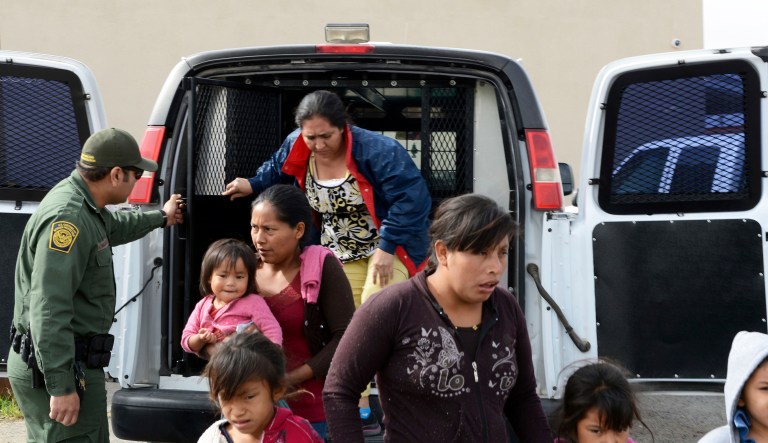 In this Friday, April 12, 2019, photo, a U.S. Border Patrol agent helps migrants out of a van at the Gospel Rescue Mission in Las Cruces, N.M.