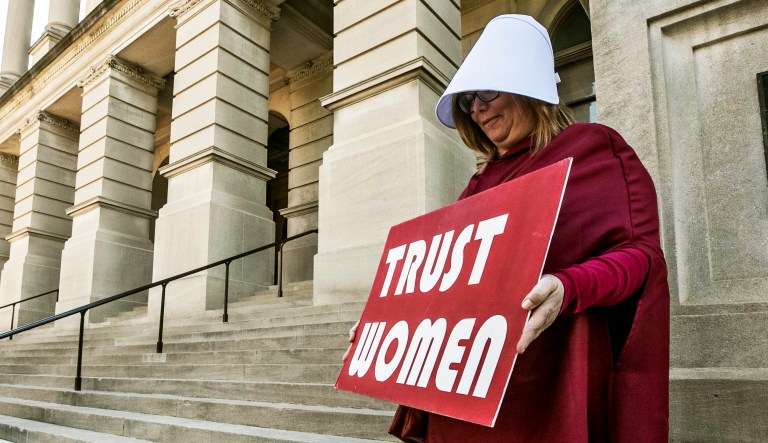 Michelle Disher, from Roswell, and others dressed as characters from "The Handmaid's Tale", protest outside the Capitol where Georgiaâs Republican Gov. Brian Kemp, was to sign legislation, Tuesday, May 7, 2019, in Atlanta.