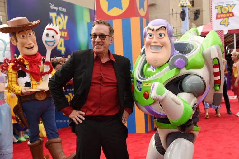 Voice cast member Tim Allen poses with his character Buzz Lightyear at the premiere of the film 