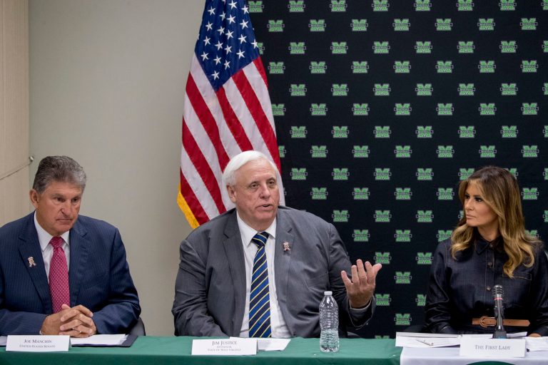 West Virginia Gov. Jim Justice, center, accompanied by Sen. Joe Manchin, left, and first lady Melania Trump, right, speaks at a roundtable on the opioid epidemic at Cabell-Huntington Health Center in Huntington, West Virginia, Monday, July 8, 2019. 