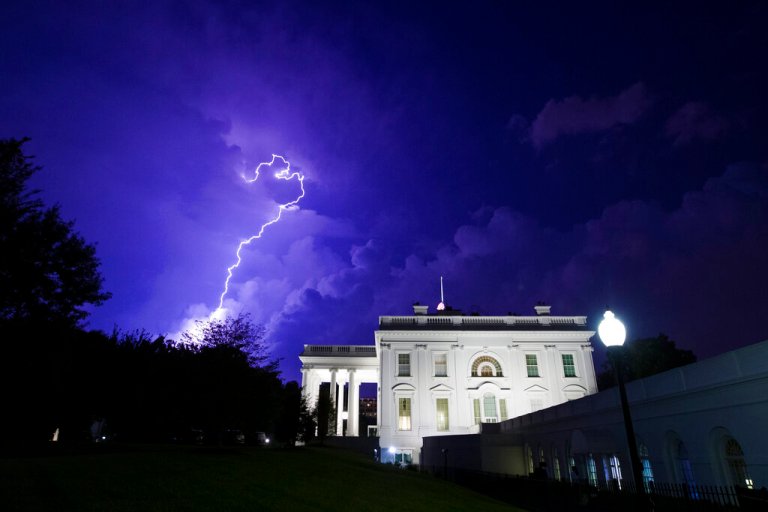 A bolt of lightning illuminates the clouds of a thunderstorm behind the White House, Tuesday, Aug. 6, 2019, in Washington.