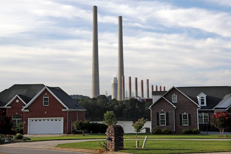 In this Aug. 7, 2019, photo, the Kingston Fossil Plant smokestacks rise above the trees behind homes in Kingston, Tenn. Fallout from the Tennessee Valley Authority's handling of a massive 2008 coal ash spill at the plant keeps growing.