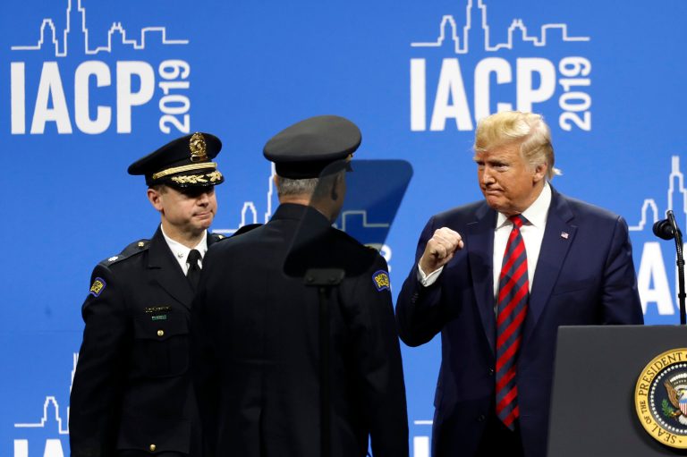 President Donald Trump recognizes Dayton, Ohio, Police Chief Richard Biehl, center, and Lt. Colonel, Assistant Chief of Police Matt Carper, at the International Association of Chiefs of Police Convention Monday, Oct. 28, 2019, in Chicago.