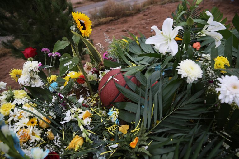 A basketball sits on a bed of flowers decorating the grave that contain the remains of 12-year-old Howard Jacob Miller Jr. at the cemetery in Colonia LeBaron, Mexico, Saturday, Nov. 9, 2019. The Juarez cartel was issued a multibillion-dollar judgment by a federal magistrate judge in North Dakota. (AP Photo/Marco Ugarte)
