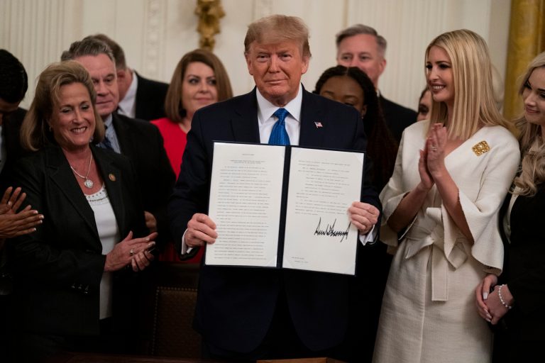 President Donald Trump shows off an executive order to help combat human trafficking in the East Room of the White House, Friday, Jan. 31, 2020, in Washington.