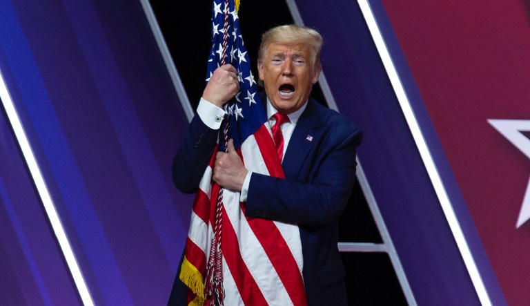 President Donald Trump hugs and kisses the American flag after speaking at Conservative Political Action Conference, CPAC 2020, at the National Harbor, in Oxon Hill, Md., Saturday, Feb. 29, 2020.