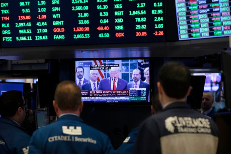 Traders listen at the New York Stock Exchange to President Donald Trump's televised speech from the White House, Friday.
