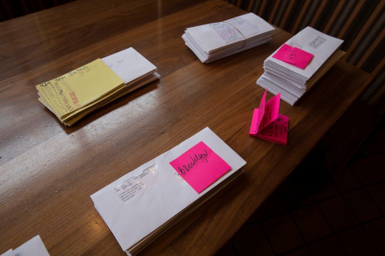 Paychecks are stacked on a table at Junior's Restaurant for distribution to employees, Thursday, March 19, 2020 in the Brooklyn borough of New York. The company has closed its four locations due to the coronavirus and is laying off 650 of 850 employees.