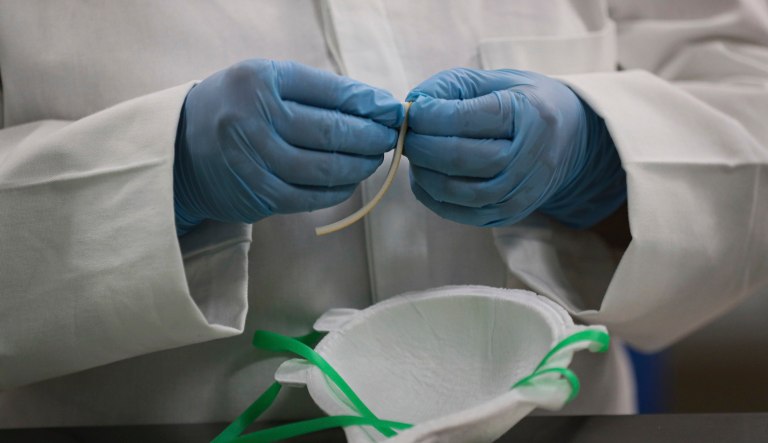 A worker adds nose protectors to face masks at a new factory in Mexico City.