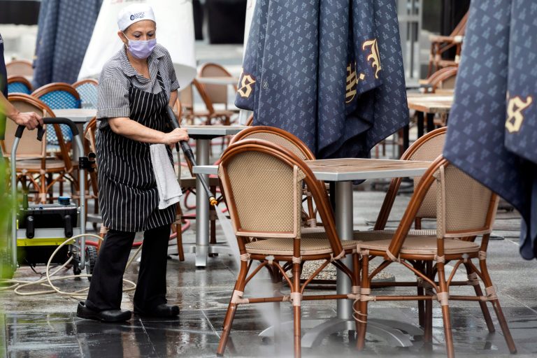 A worker at Brasserie Beck, a restaurant along K Street in downtown Washington, power washes the outdoor seating area. A new survey warns businesses that some employees will sue if they get coronavirus after returning to work.