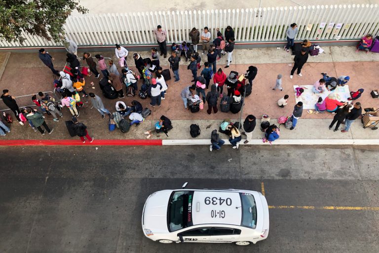 Migrants gathered last November at the U.S.-Mexico border in Tijuana, Mexico, to hear names called from a waiting list to claim asylum in the U.S.