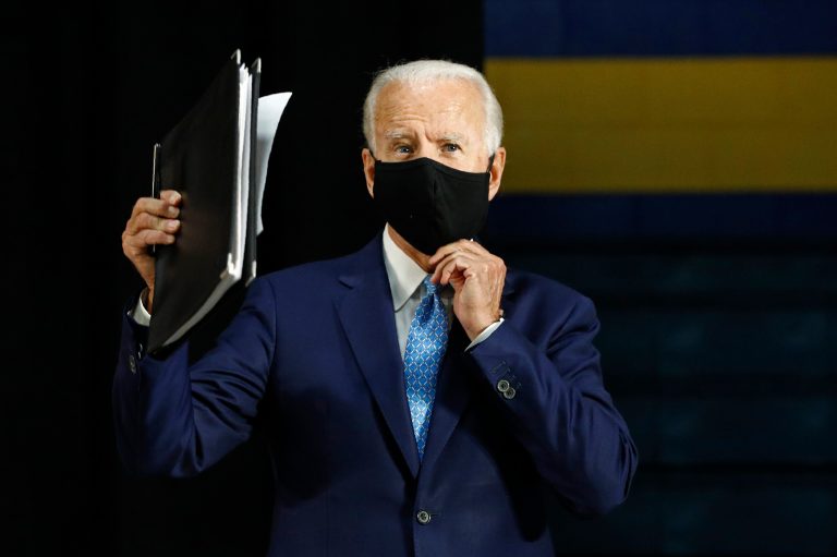 Democratic presidential candidate, former Vice President Joe Biden puts on a face mask to protect against the spread of the new coronavirus as he departs after speaking at Alexis Dupont High School in Wilmington, Del., Tuesday, June 30, 2020.