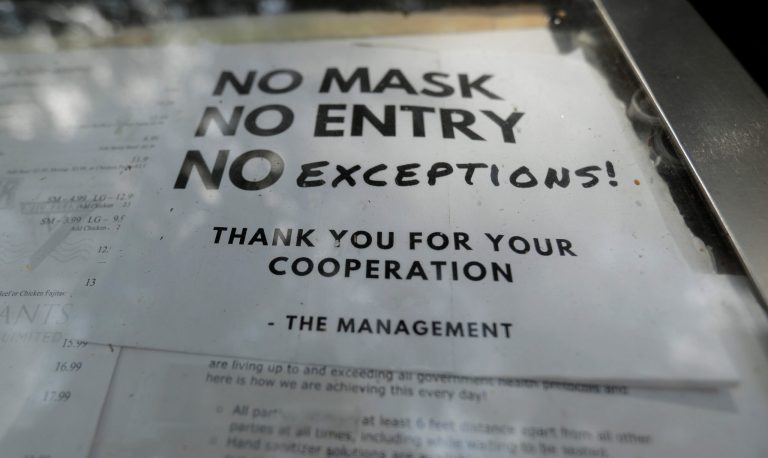 A sign requiring face masks to protect against the spread of COVID-19 is seen at a restaurant in San Antonio.