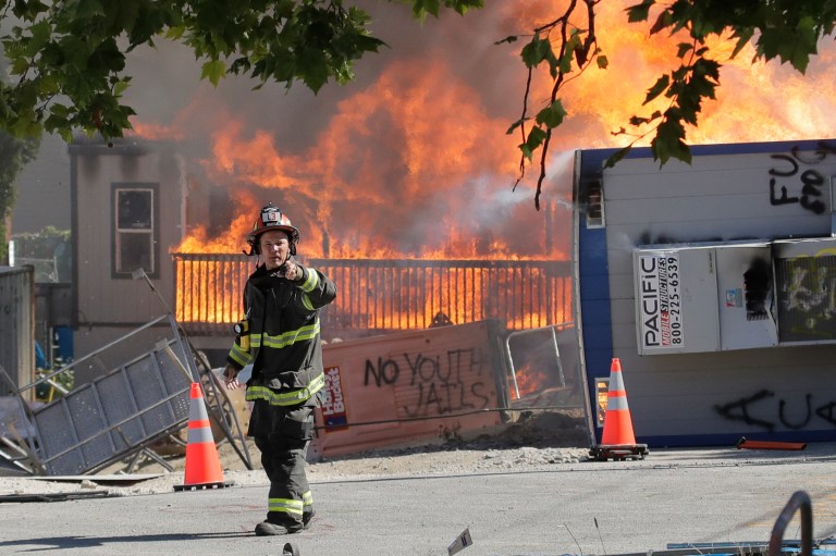 Construction buildings burn near the King County Juvenile Detention Center, Saturday, July 25, 2020, in Seattle, shortly after a group of protesters left the area. A large group of protesters were marching Saturday in Seattle in support of Black Lives Matter.