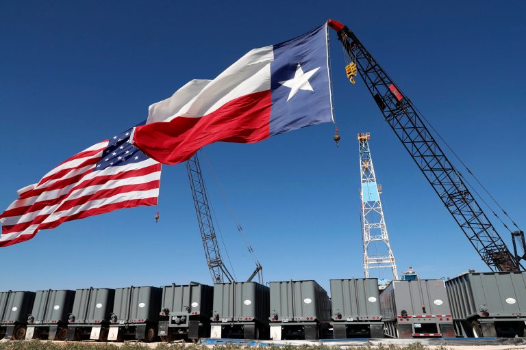 An American flag and a Texas flag fly off the tip of cranes by an oil rig near the site where then-President Donald Trump delivered remarks about American energy production during a visit to the Double Eagle Energy Oil Rig, Wednesday, July 29, 2020, in Midland, Texas.