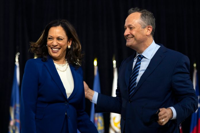 Democratic presidential candidate former Vice President Joe Biden's running mate Sen. Kamala Harris, D-Calif., and her husband Douglas Emhoff stand together during a campaign event at Alexis Dupont High School in Wilmington, Del., Wednesday.