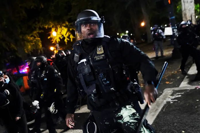 A Portland police officer pushes back protesters, Saturday, Sept. 26, 2020, in Portland. The protests, which began over the killing of George Floyd, often result frequent clashes between protesters and law enforcement.