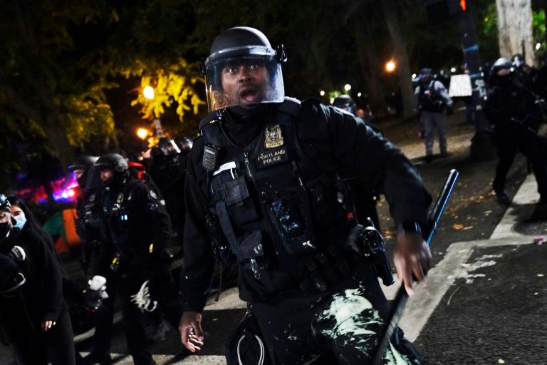 A Portland police officer pushes back protesters, Saturday, Sept. 26, 2020, in Portland. The protests, which began over the killing of George Floyd, often result frequent clashes between protesters and law enforcement.