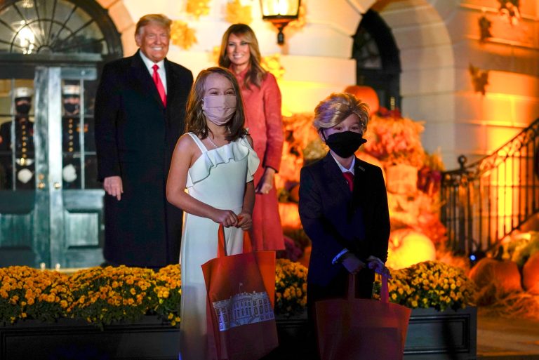 President Donald Trump and first lady Melania Trump poses for a photo with children dressed as them as they greet two trick-or-treaters dressed like them on the South Lawn during a Halloween celebration at the White House, Sunday, Oct. 25, 2020 in Washington.