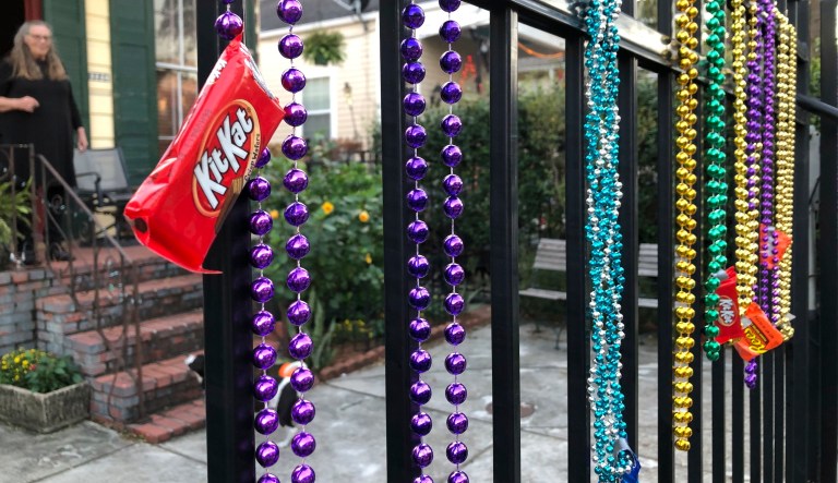A New Orleans homeowner uses beads as a socially distant way to deliver candy on Halloween, Saturday, Oct. 31, 2020.
