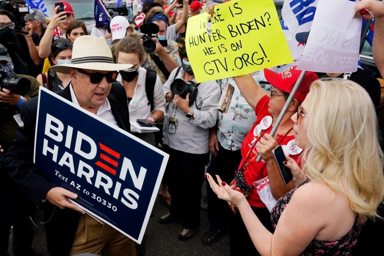 Supporters of President Donald Trump, right, engage a supporter of Democratic presidential candidate Joe Biden, left, at a rally outside the Maricopa County Recorder's Office, Friday, Nov. 6, 2020, in Phoenix.